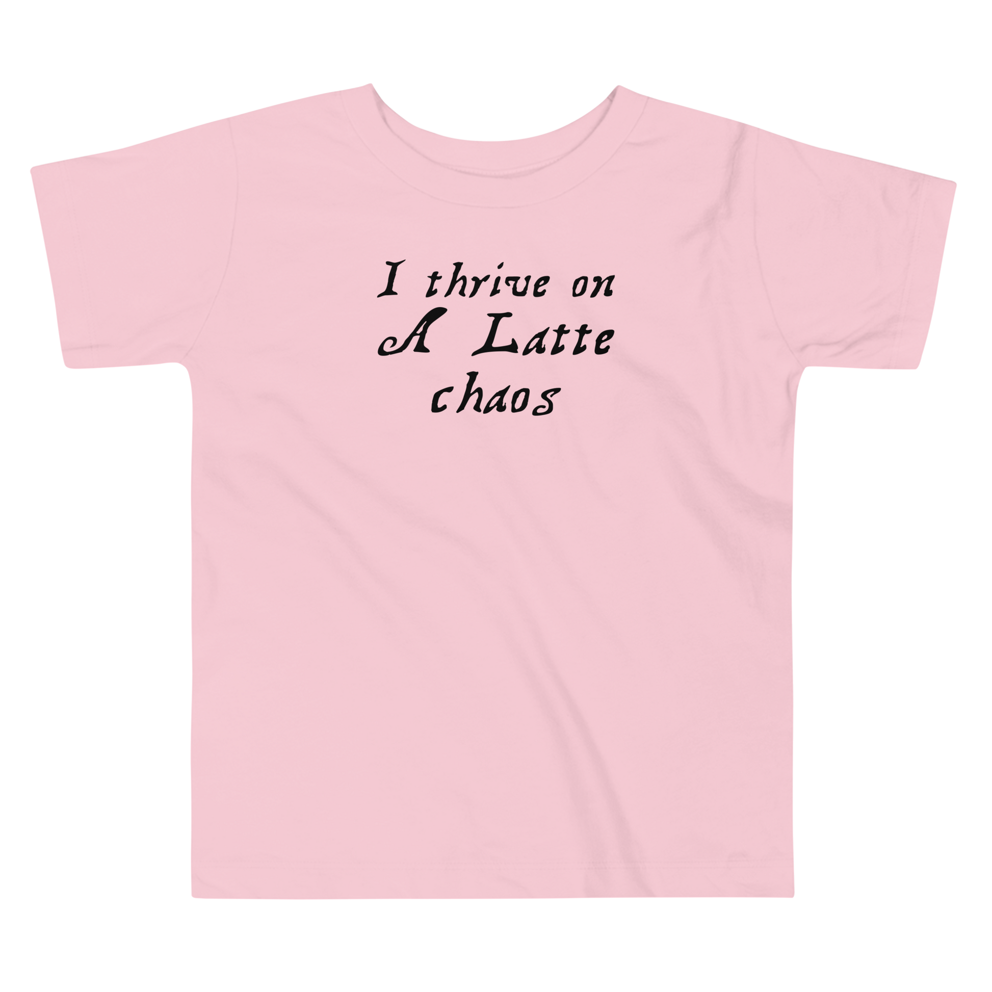 "I thrive on a latte chaos" printed on a pink toddler short sleeve tee laying on a flat surface