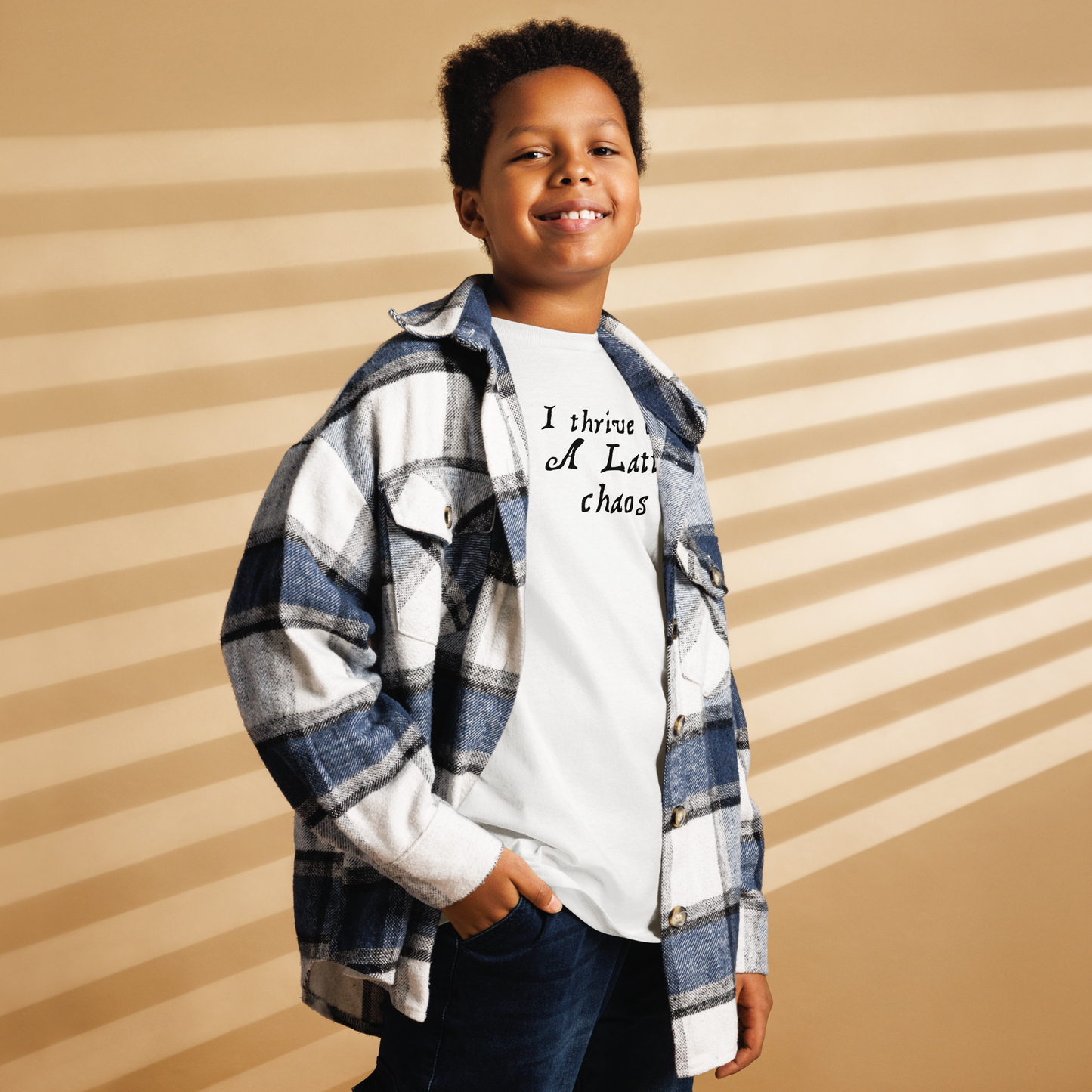 "I thrive on a latte chaos" printed on a white youth classic tee worn by a male also wearing a jacket