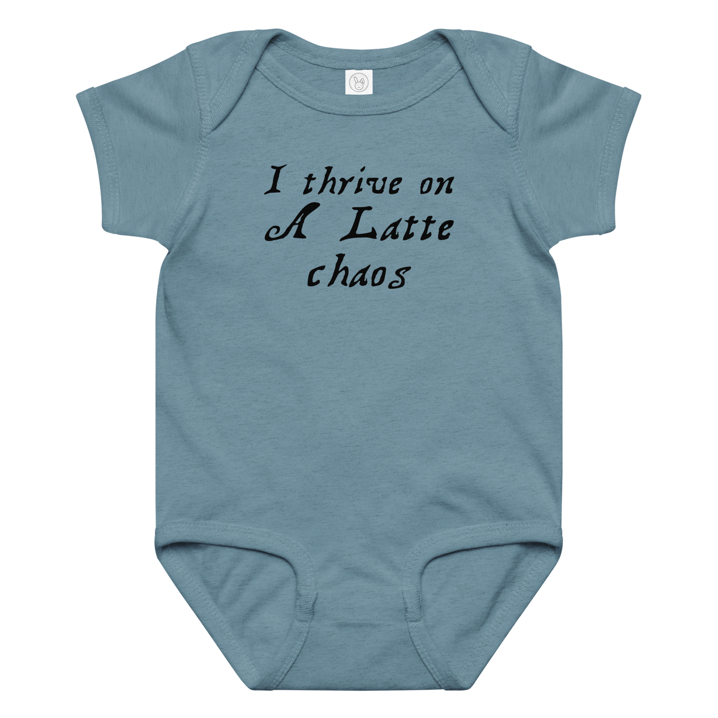 "I thrive on a latte chaos" printed on a vintage indigo baby jersey bodysuit laying on a flat surface amongst other clothes