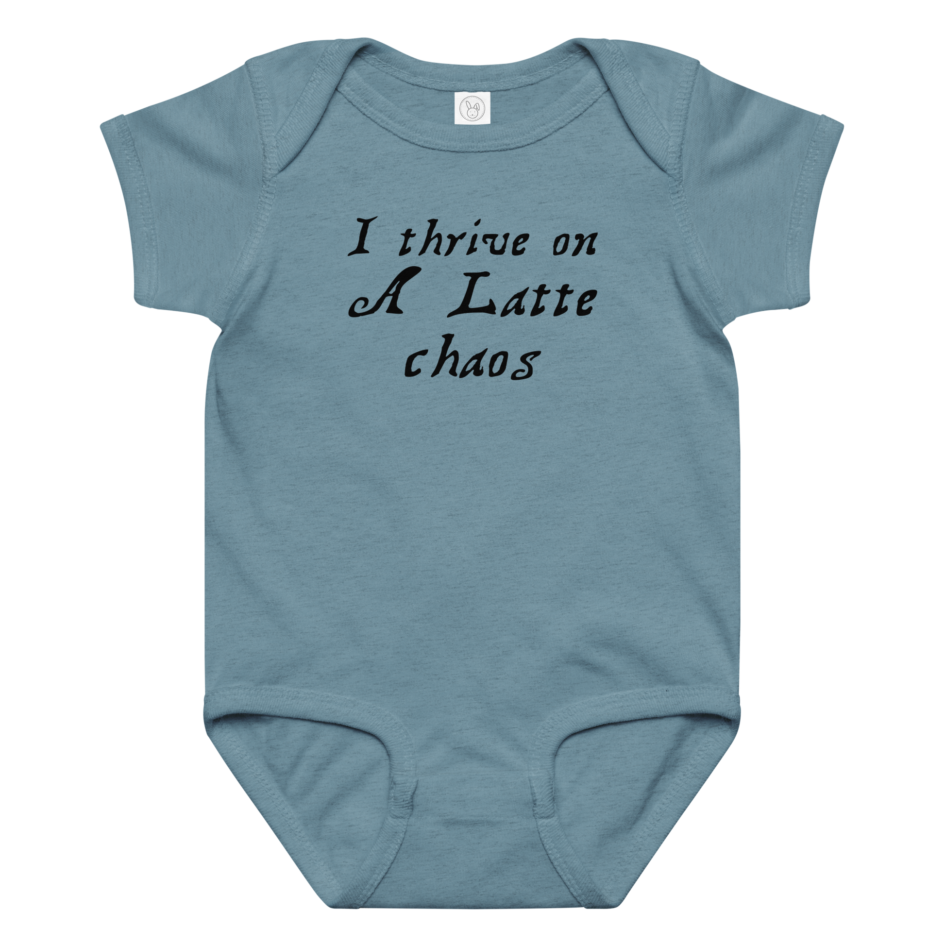 "I thrive on a latte chaos" printed on a vintage indigo baby jersey bodysuit laying on a flat surface amongst other clothes