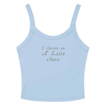 "I thrive on a latte chaos" printed on a solid baby blue blend women's micro-rib tanktop laying on a flat surface amongst sunglasses and shorts