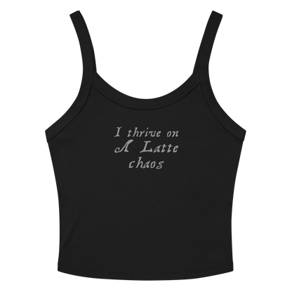 "I thrive on a latte chaos" printed on a solid black blend women's micro-rib tanktop laying on a flat surface amongst sunglasses and shorts