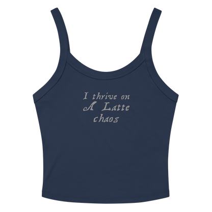 "I thrive on a latte chaos" printed on a solid navy blend women's micro-rib tanktop laying on a flat surface amongst sunglasses and shorts