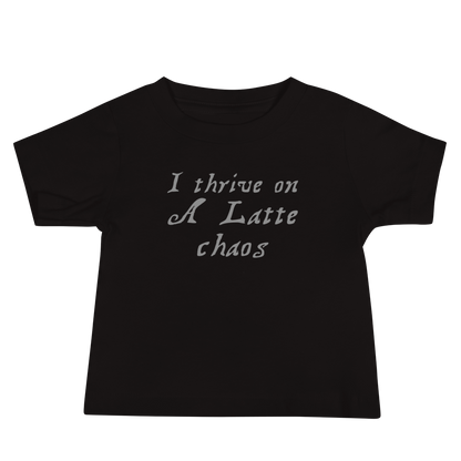 "I thrive on a latte chaos" printed on a black baby jersey short sleeve tee laying on a flat surface