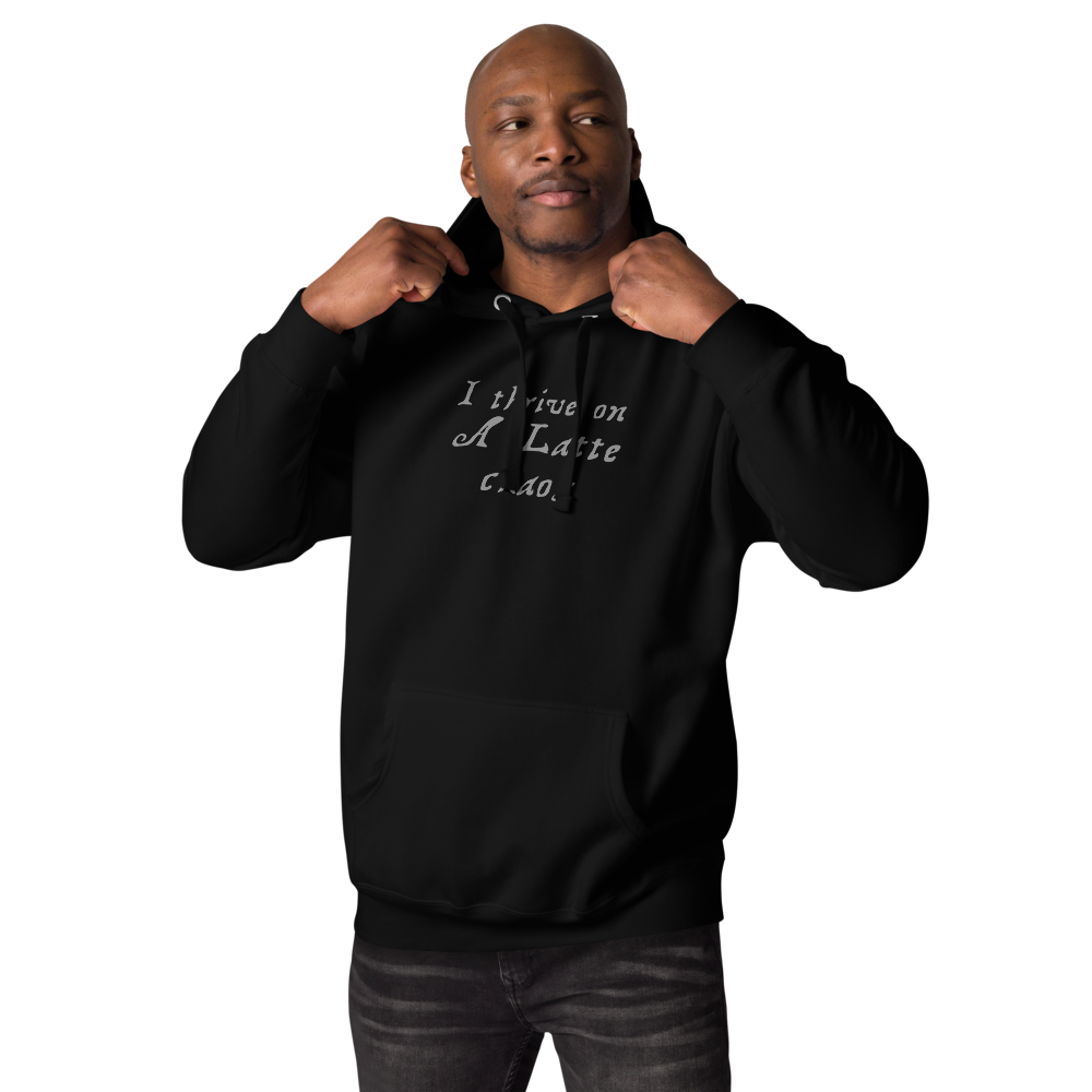 "I thrive on a latte chaos" printed on a black unisex hoodie worn by a male