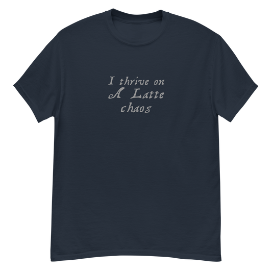 "I thrive on a latte chaos" printed on a navy unisex classic tee laying on a flat surface