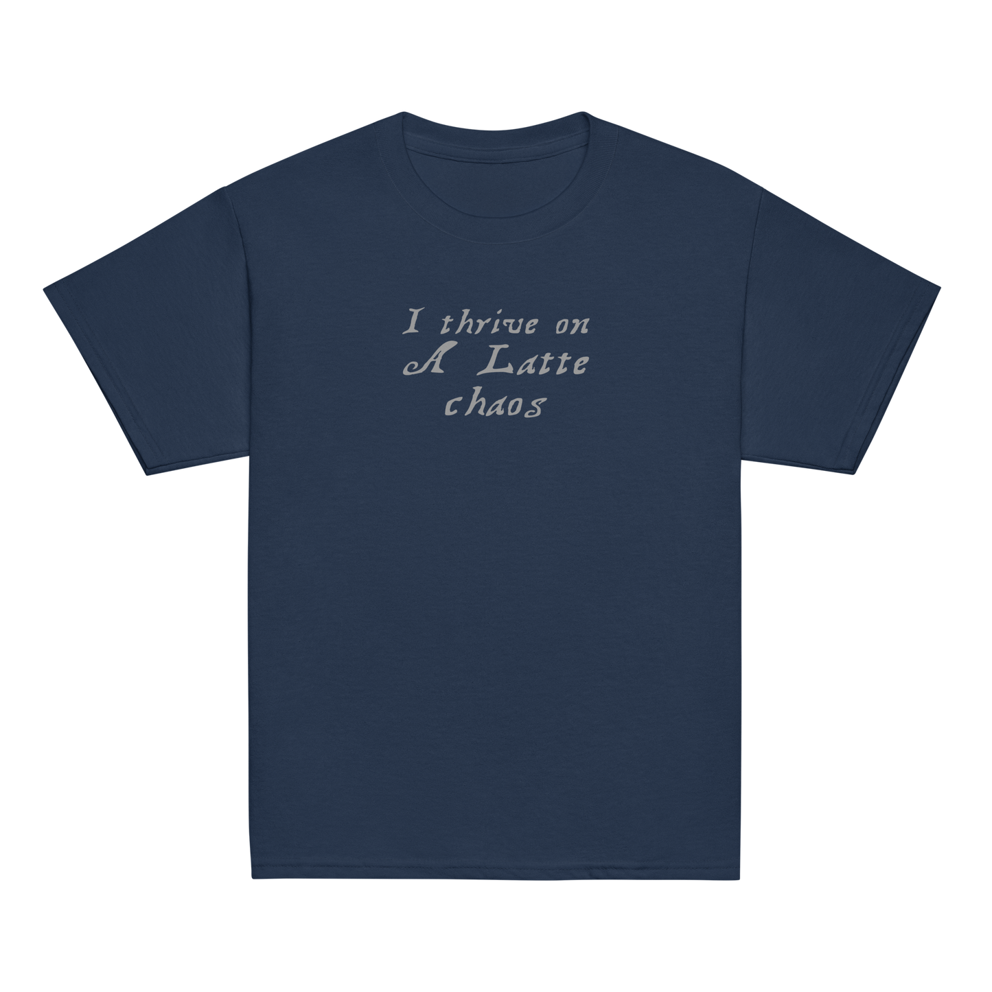 "I thrive on a latte chaos" printed on a navy youth classic tee laying on a flat surface