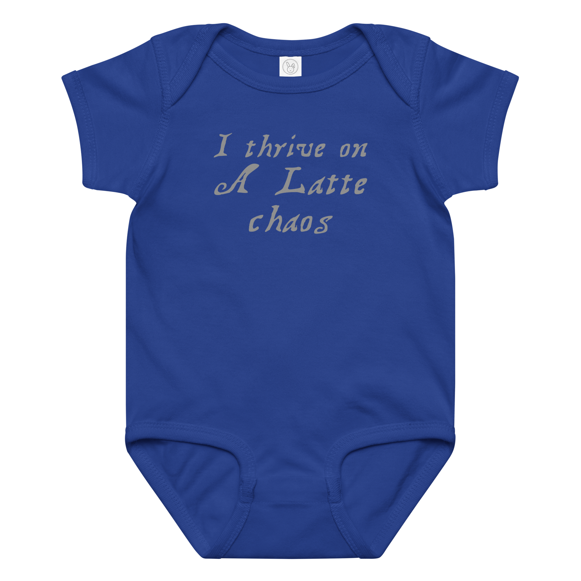 "I thrive on a latte chaos" printed on a royal baby jersey bodysuit laying on a flat surface amongst other clothes