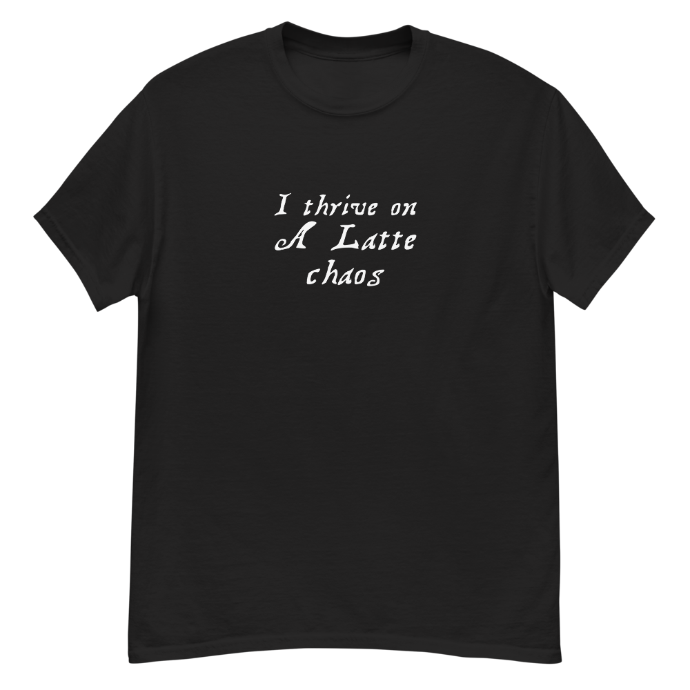 "I thrive on a latte chaos" printed on a black unisex classic tee laying on a flat surface