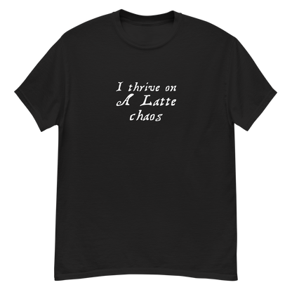 "I thrive on a latte chaos" printed on a black unisex classic tee laying on a flat surface
