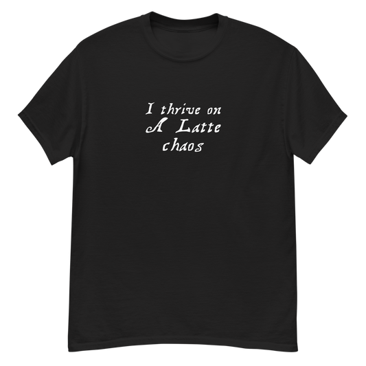 "I thrive on a latte chaos" printed on a black unisex classic tee laying on a flat surface