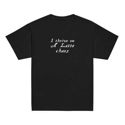 "I thrive on a latte chaos" printed on a black youth classic tee laying on a flat surface