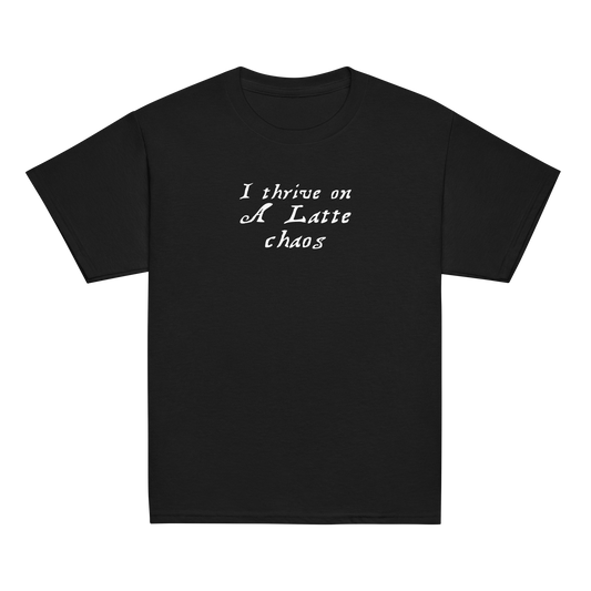 "I thrive on a latte chaos" printed on a black youth classic tee laying on a flat surface