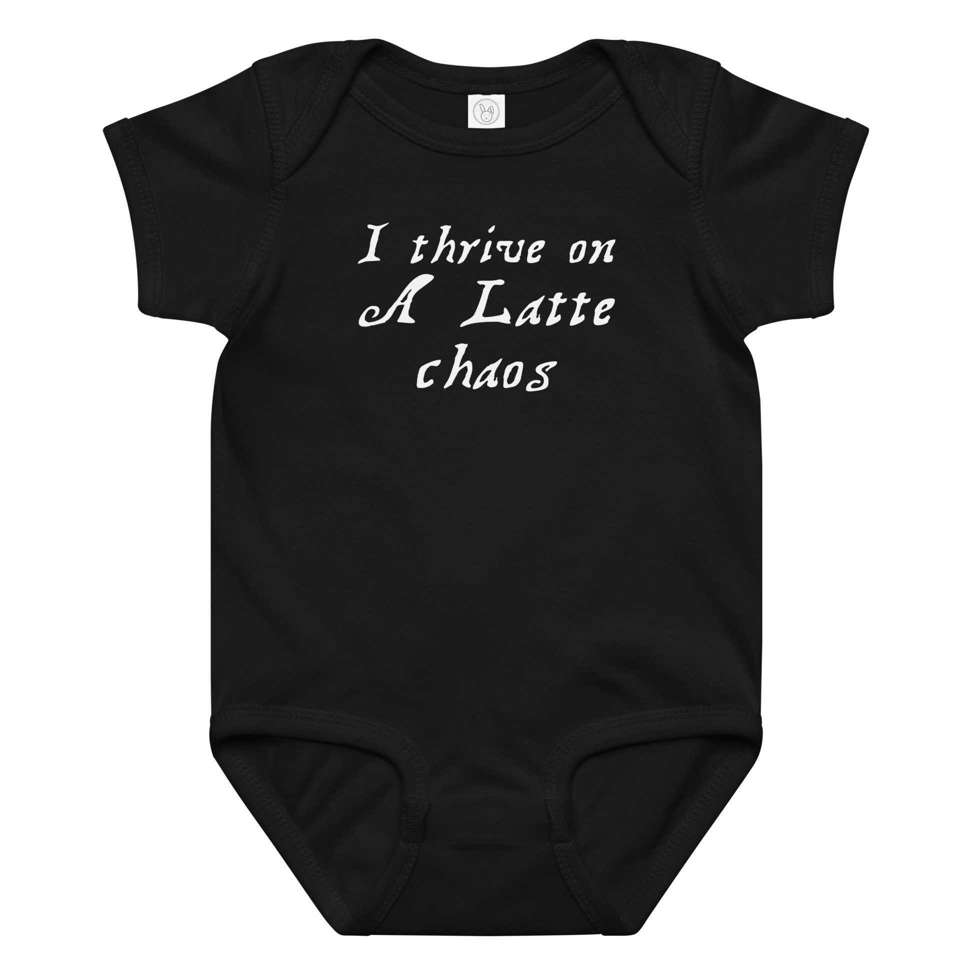 "I thrive on a latte chaos" printed on a black baby jersey bodysuit laying on a flat surface amongst other clothes