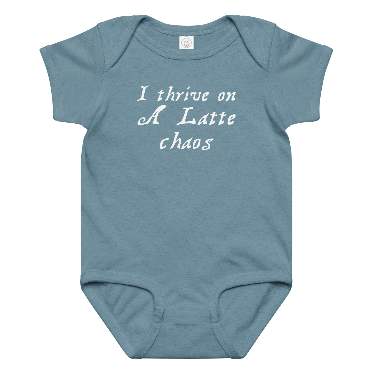 "I thrive on a latte chaos" printed on a vintage indigo baby jersey bodysuit laying on a flat surface amongst other clothes