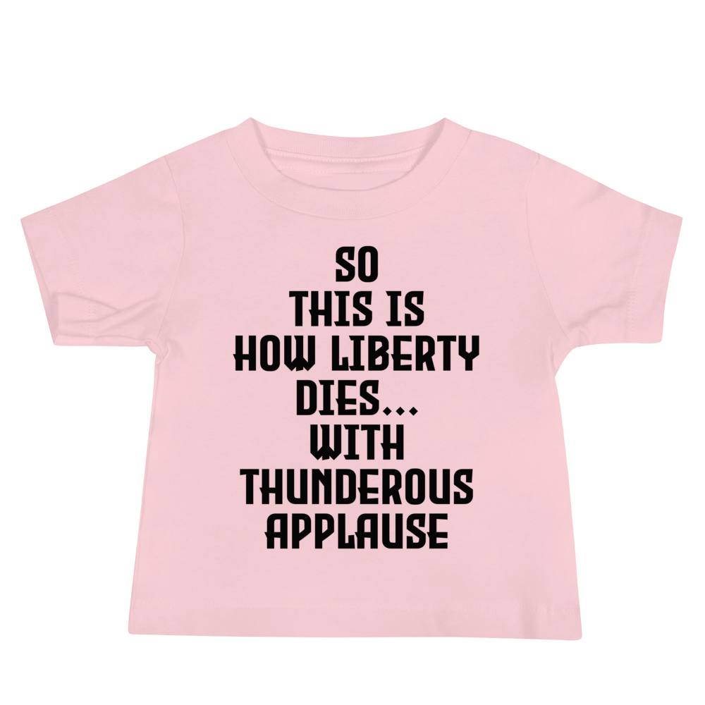 "So this is how liberty dies… with thunderous applause" printed on a pink baby jersey short sleeve tee laying on a flat surface