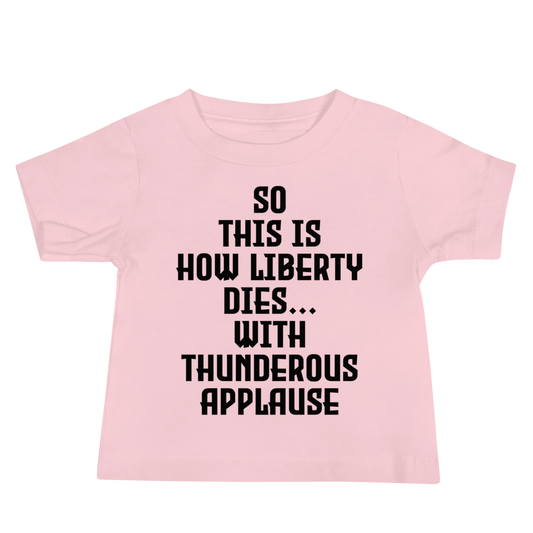 "So this is how liberty dies… with thunderous applause" printed on a pink baby jersey short sleeve tee laying on a flat surface