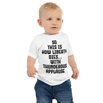 "So this is how liberty dies… with thunderous applause" printed on a white baby jersey short sleeve tee worn by a male