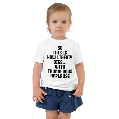 "So this is how liberty dies… with thunderous applause" printed on a white toddler short sleeve tee worn by a female