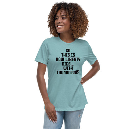 "So this is how liberty dies… with thunderous applause" printed on a heather blue lagoon women's relaxed t-shirt worn by a female