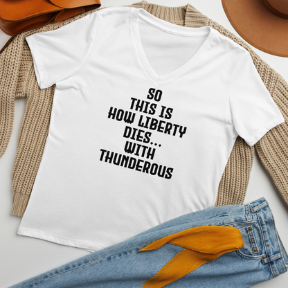 "So this is how liberty dies… with thunderous applause" printed on a solid white blend women's relaxed v-neck t-shirt laying on a flat surface amongst other clothes