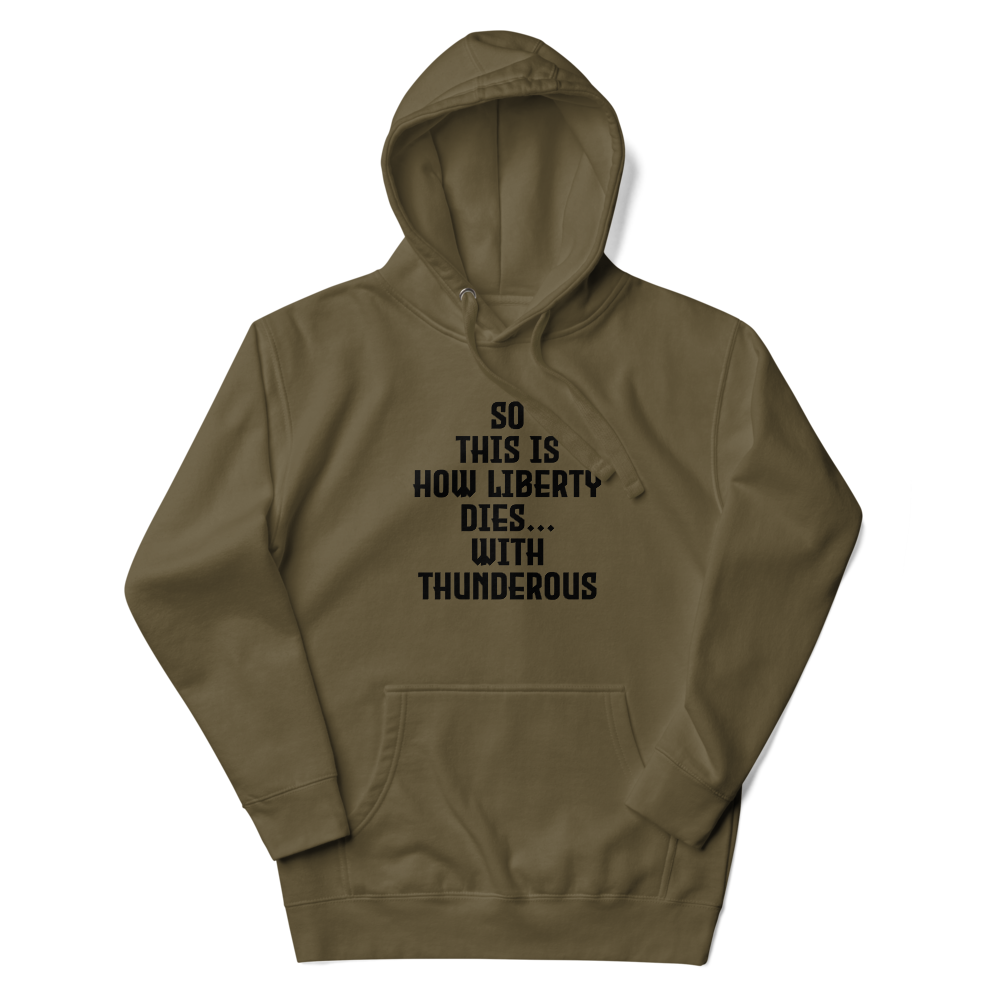 "So this is how liberty dies… with thunderous applause" printed on a military green unisex hoodie laying on a flat surface with the hood up