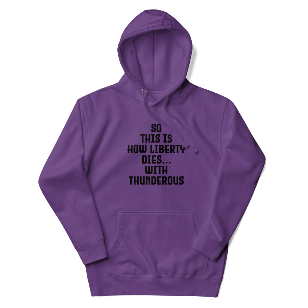 "So this is how liberty dies… with thunderous applause" printed on a purple unisex hoodie laying on a flat surface with the hood up
