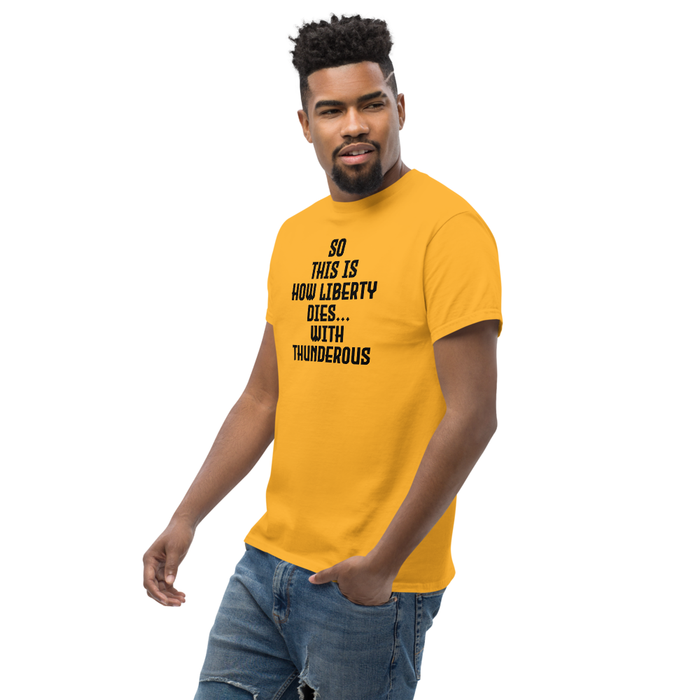 "So this is how liberty dies… with thunderous applause" printed on a gold unisex classic tee worn by a male