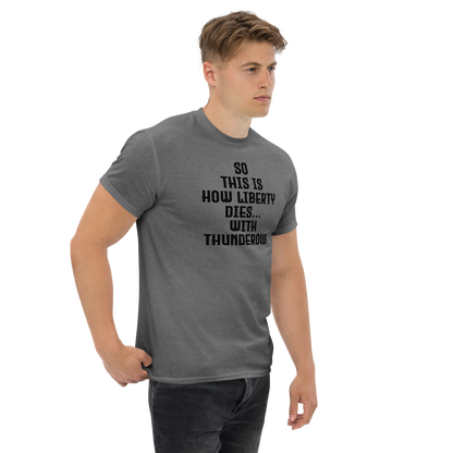 "So this is how liberty dies… with thunderous applause" printed on a graphite heather unisex classic tee worn by a male