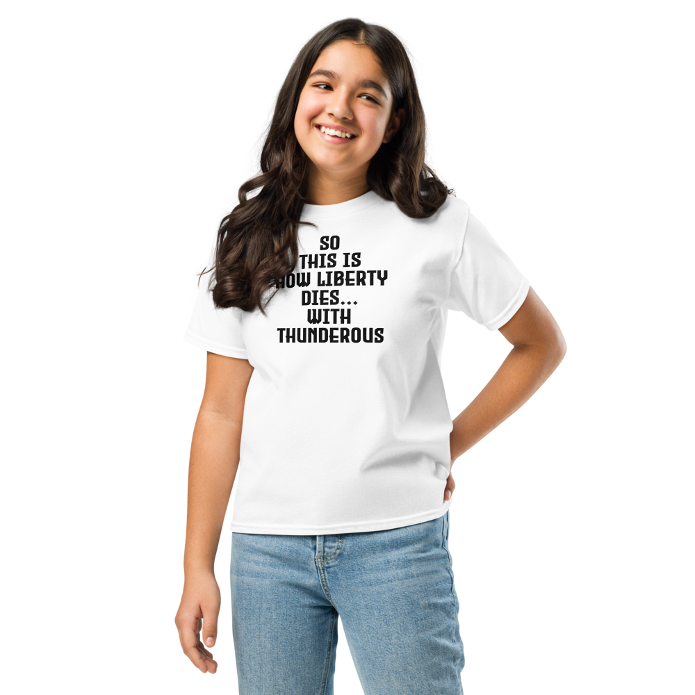 "So this is how liberty dies… with thunderous applause" printed on a white youth classic tee worn by a female