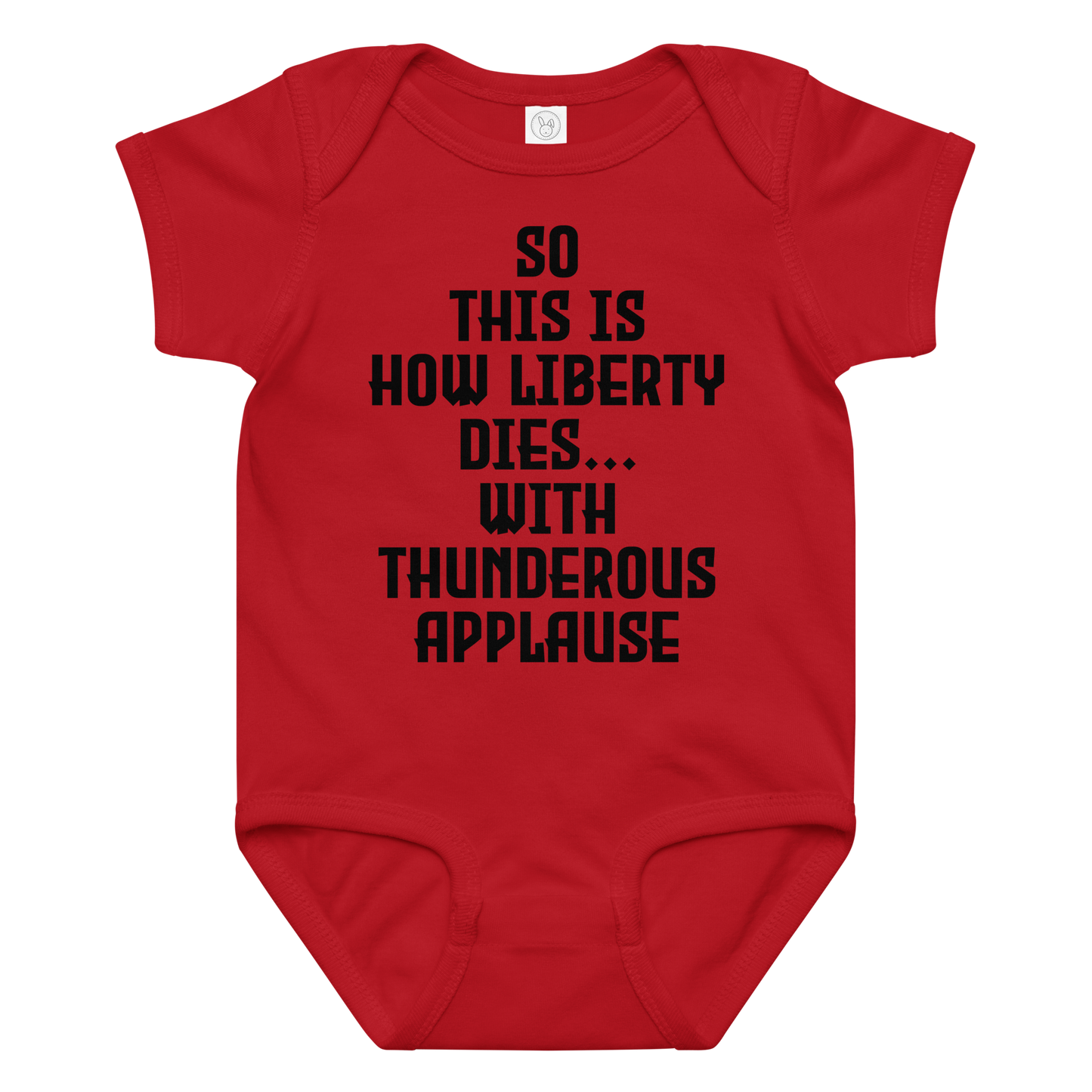 "So this is how liberty dies… with thunderous applause" printed on a red baby jersey bodysuit laying on a flat surface amongst other clothes