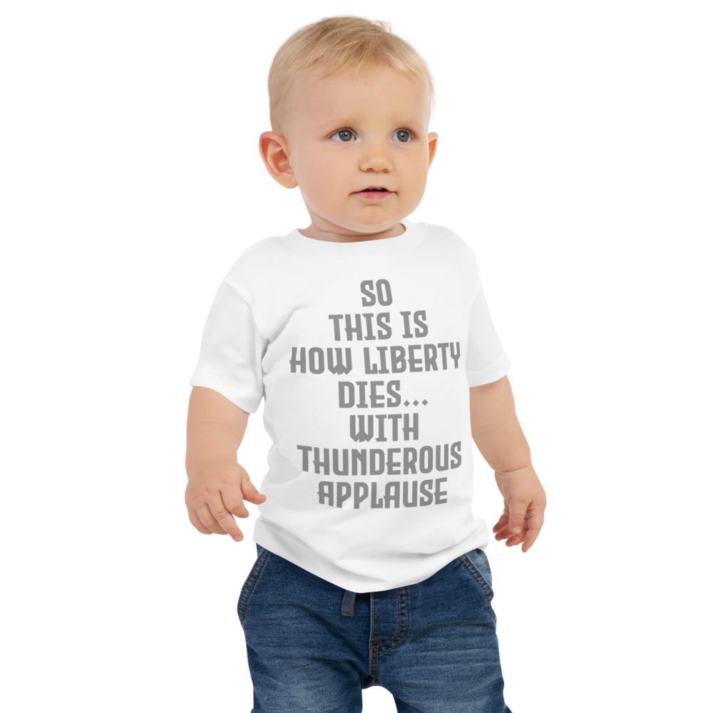 "So this is how liberty dies… with thunderous applause" printed on a white baby jersey short sleeve tee worn by a male