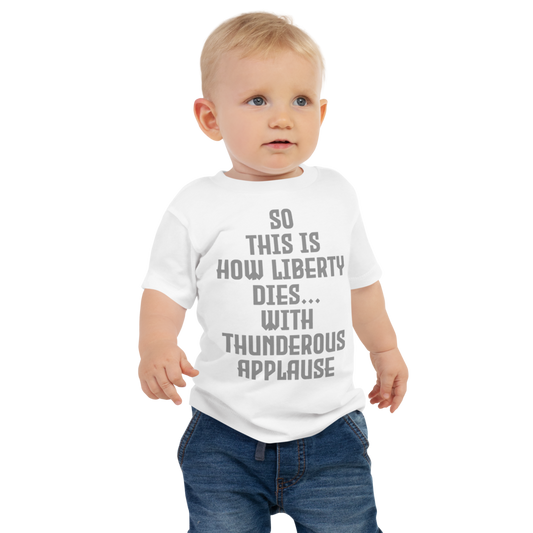 "So this is how liberty dies… with thunderous applause" printed on a white baby jersey short sleeve tee worn by a male