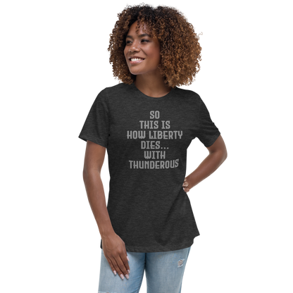 "So this is how liberty dies… with thunderous applause" printed on a dark grey heather women's relaxed t-shirt worn by a female