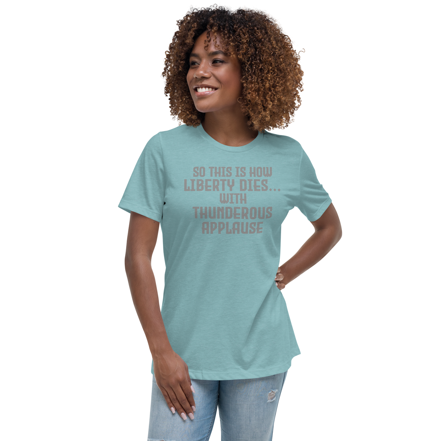 "So this is how liberty dies… with thunderous applause" printed on a heather blue lagoon women's relaxed t-shirt worn by a female