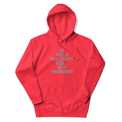 "So this is how liberty dies… with thunderous applause" printed on a team red unisex hoodie laying on a flat surface with the hood up