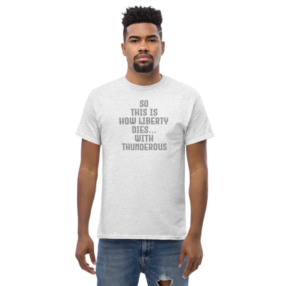 "So this is how liberty dies… with thunderous applause" printed on a ash unisex classic tee worn by a male