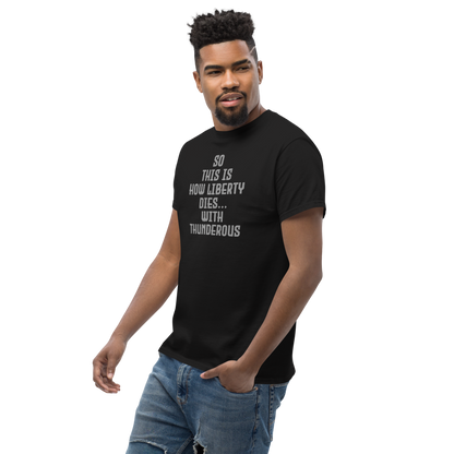 "So this is how liberty dies… with thunderous applause" printed on a black unisex classic tee worn by a male