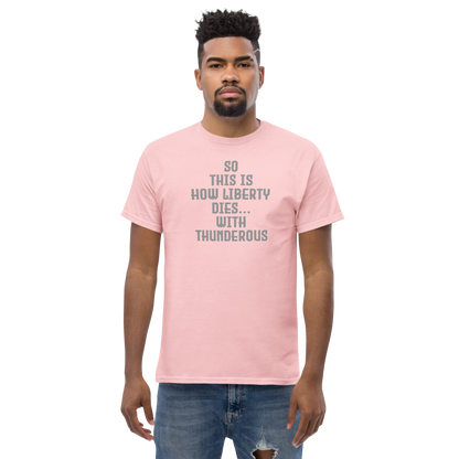 "So this is how liberty dies… with thunderous applause" printed on a light pink unisex classic tee worn by a male
