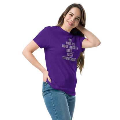 "So this is how liberty dies… with thunderous applause" printed on a purple unisex classic tee worn by a female