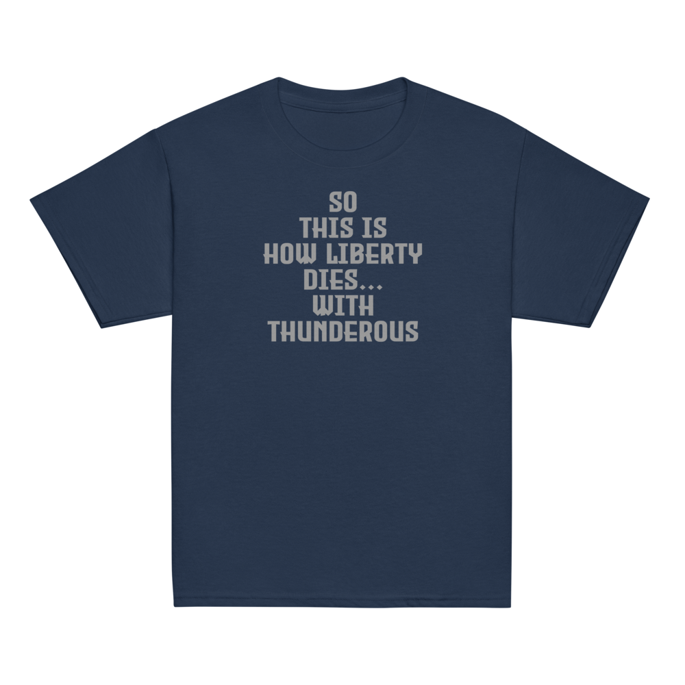 "So this is how liberty dies… with thunderous applause" printed on a navy youth classic tee laying on a flat surface
