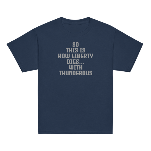 "So this is how liberty dies… with thunderous applause" printed on a navy youth classic tee laying on a flat surface
