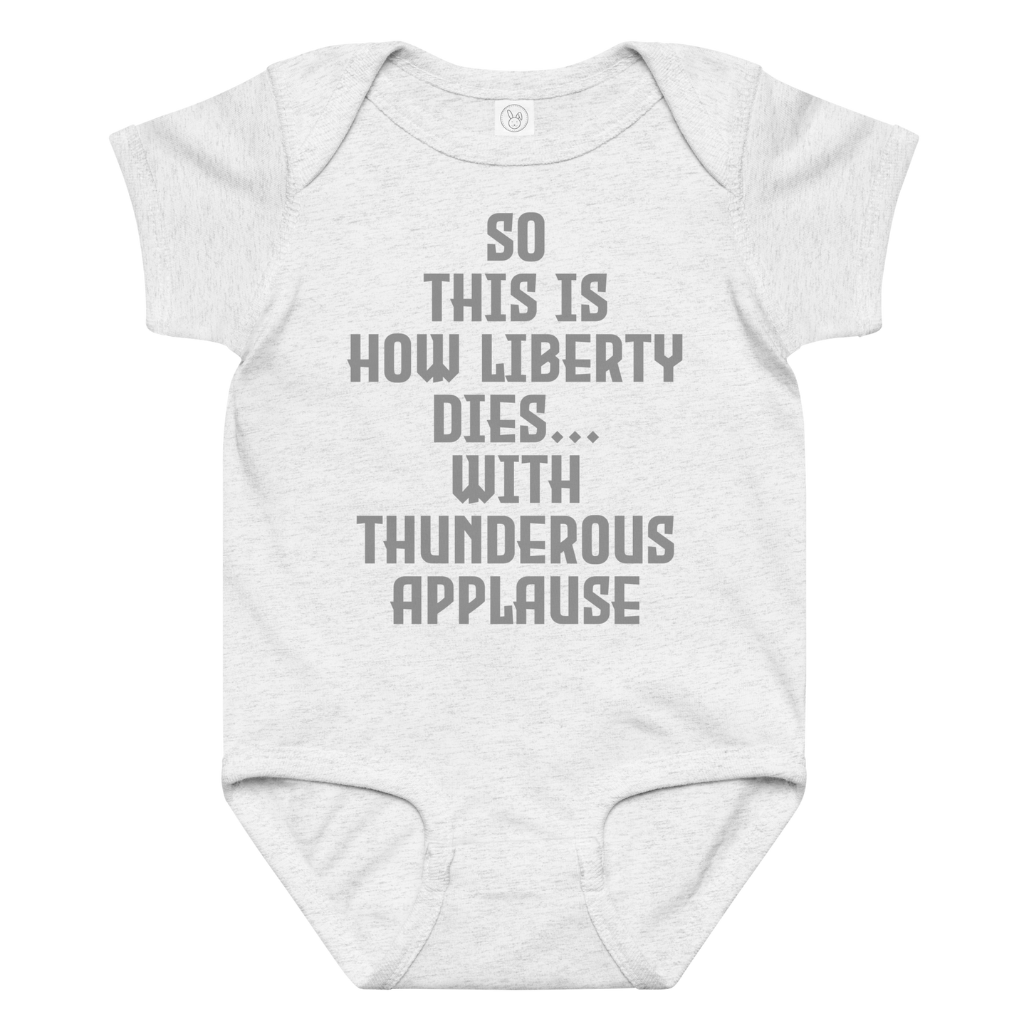 "So this is how liberty dies… with thunderous applause" printed on a ash baby jersey bodysuit laying on a flat surface amongst other clothes