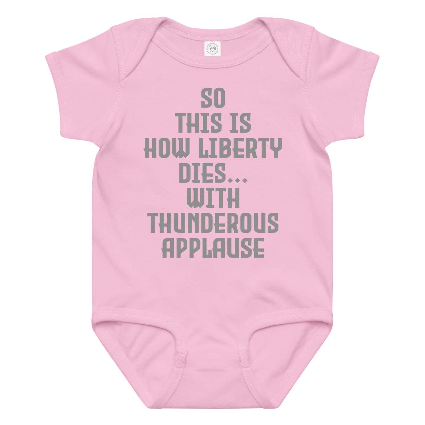 "So this is how liberty dies… with thunderous applause" printed on a pink baby jersey bodysuit laying on a flat surface amongst other clothes