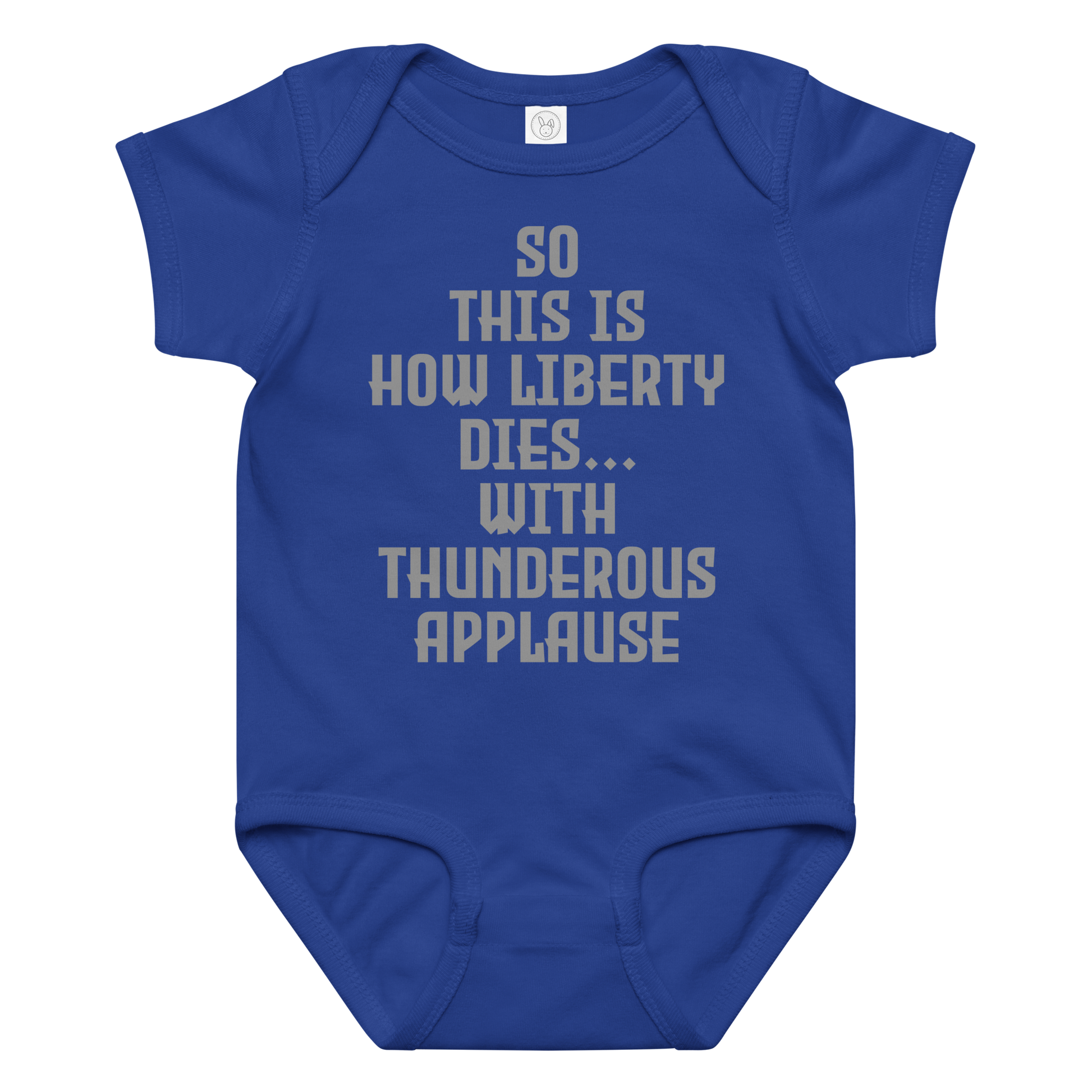 "So this is how liberty dies… with thunderous applause" printed on a royal baby jersey bodysuit laying on a flat surface amongst other clothes
