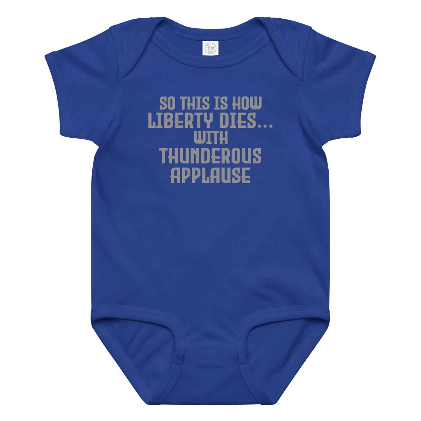 "So this is how liberty dies… with thunderous applause" printed on a royal baby jersey bodysuit laying on a flat surface amongst other clothes