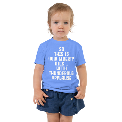 "So this is how liberty dies… with thunderous applause" printed on a heather columbia blue toddler short sleeve tee worn by a female