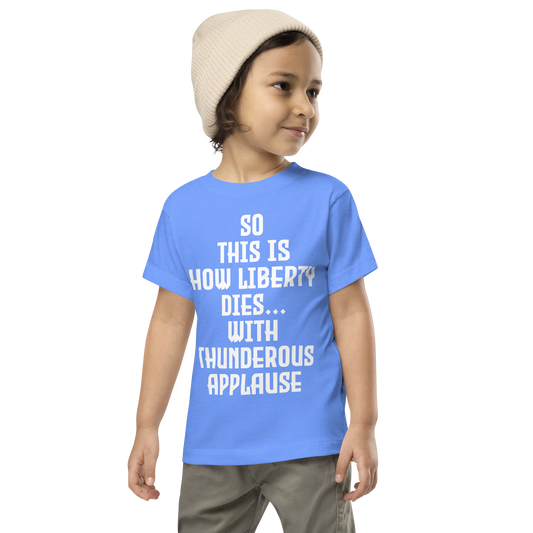 "So this is how liberty dies… with thunderous applause" printed on a heather columbia blue toddler short sleeve tee worn by a male wearing a cap