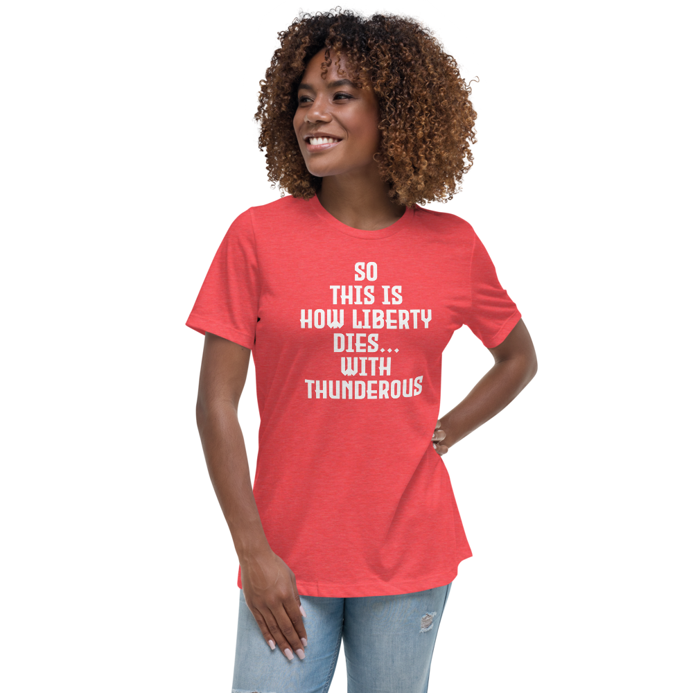 "So this is how liberty dies… with thunderous applause" printed on a heather red women's relaxed t-shirt worn by a female