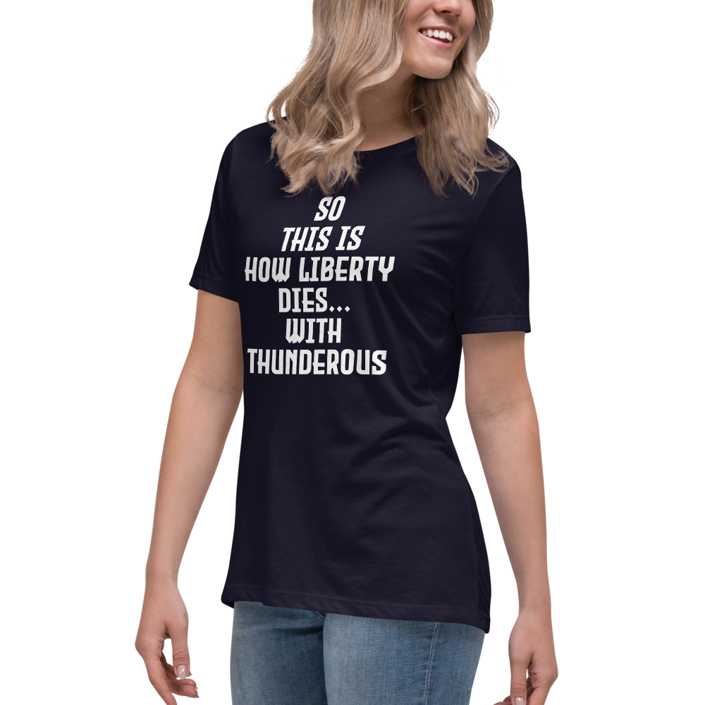 "So this is how liberty dies… with thunderous applause" printed on a navy women's relaxed t-shirt worn by a female